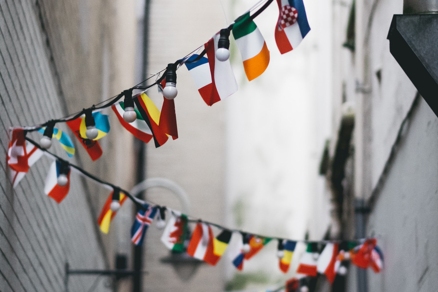 Små flaggor för olika länder som hänger över en smal gata. 